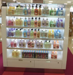 A double-sided retail display showcases soaps and lotions.