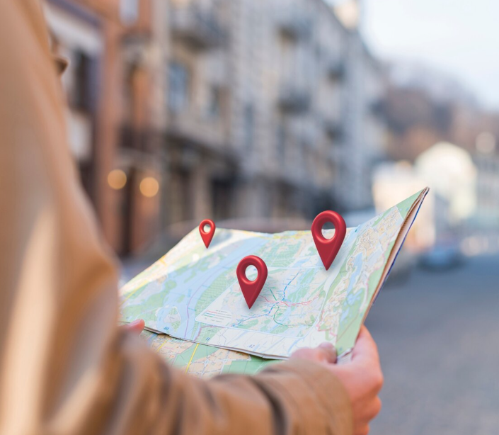 A person holding a map with 3D pins on it.