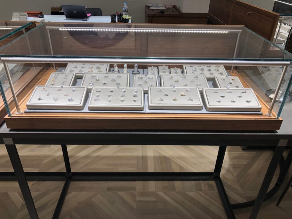 rings on display in a glass retail jewelry case